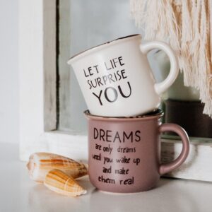 white and black ceramic mug on brown wooden table